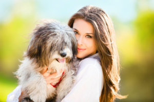 A Woman holding a pet dog in her arms