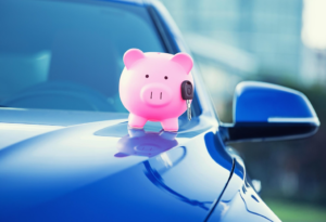 A piggy bank on a car's bonnet